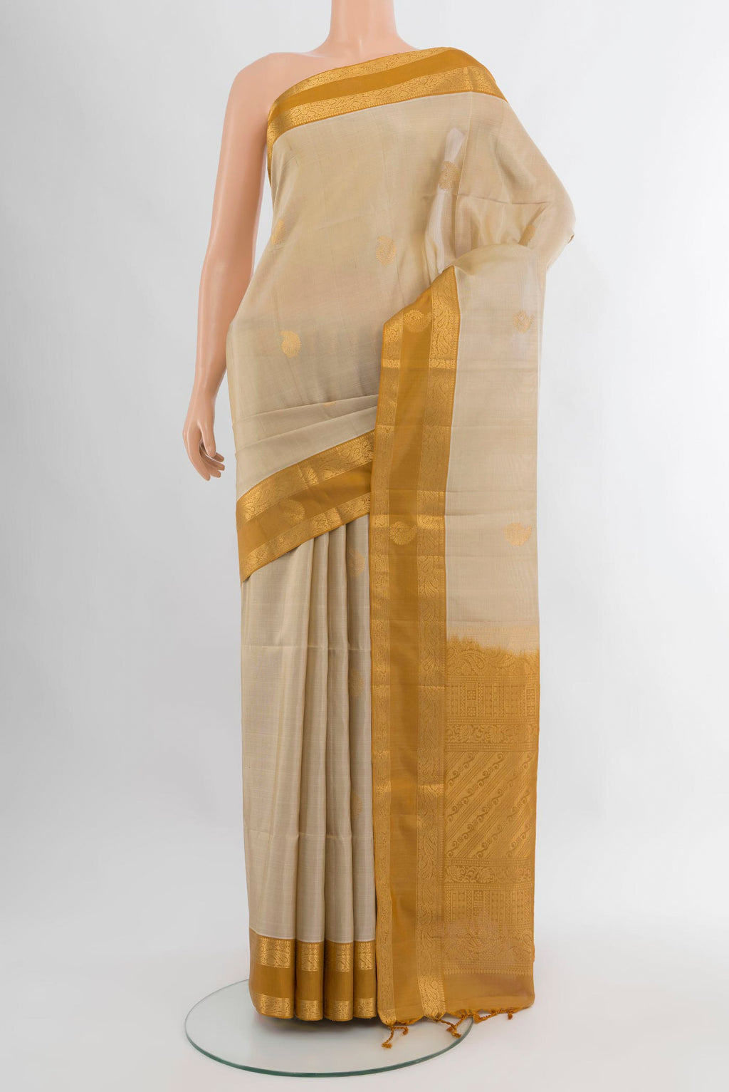 Beige Soft Silk Saree with Zari Butta on the body and Zari Border.  displayed on a mannequin