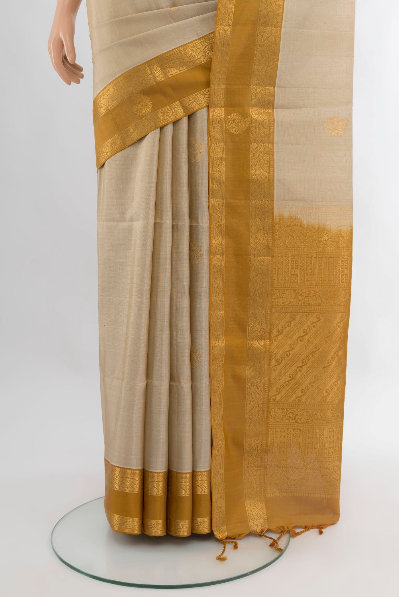 Pleats and pallu of Beige Soft Silk Saree with Zari Butta on the body and Zari Border. 