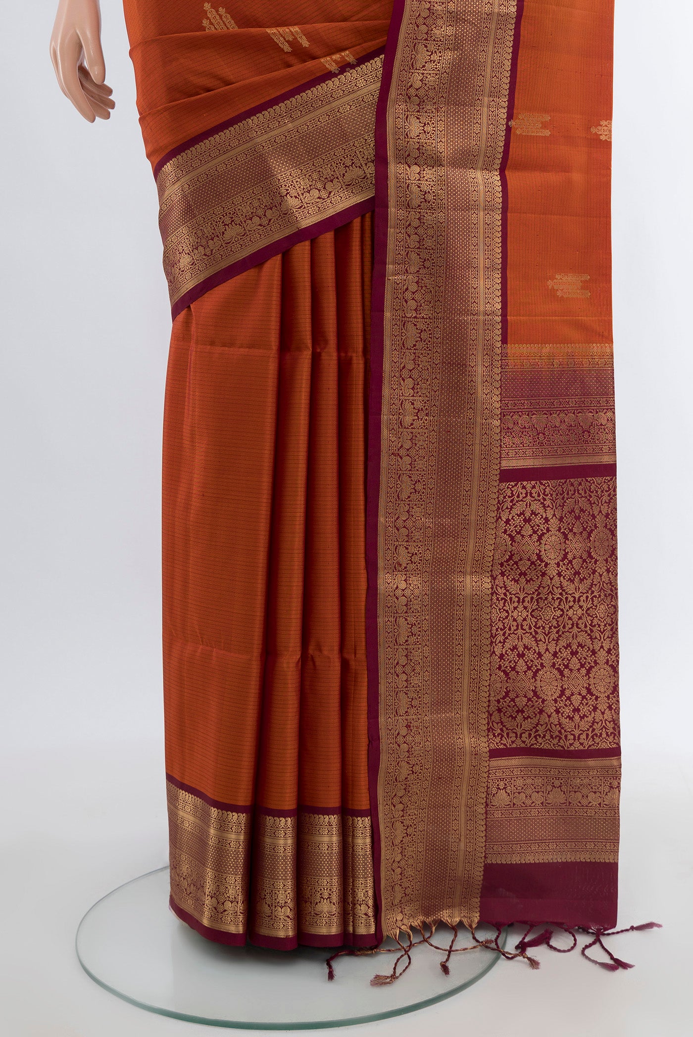 Pleats and pallu of Rust Soft Silk Saree with Zari Butta on the body and Zari Border. 