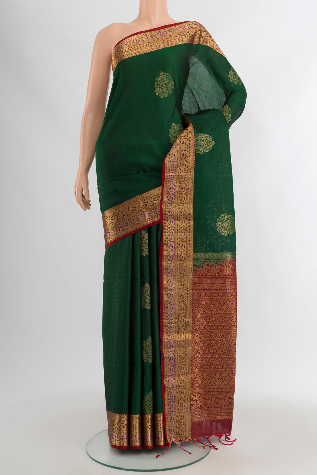 Bottle Green Soft Silk Saree with Zari Butta on the body and Zari Border.  displayed on a mannequin