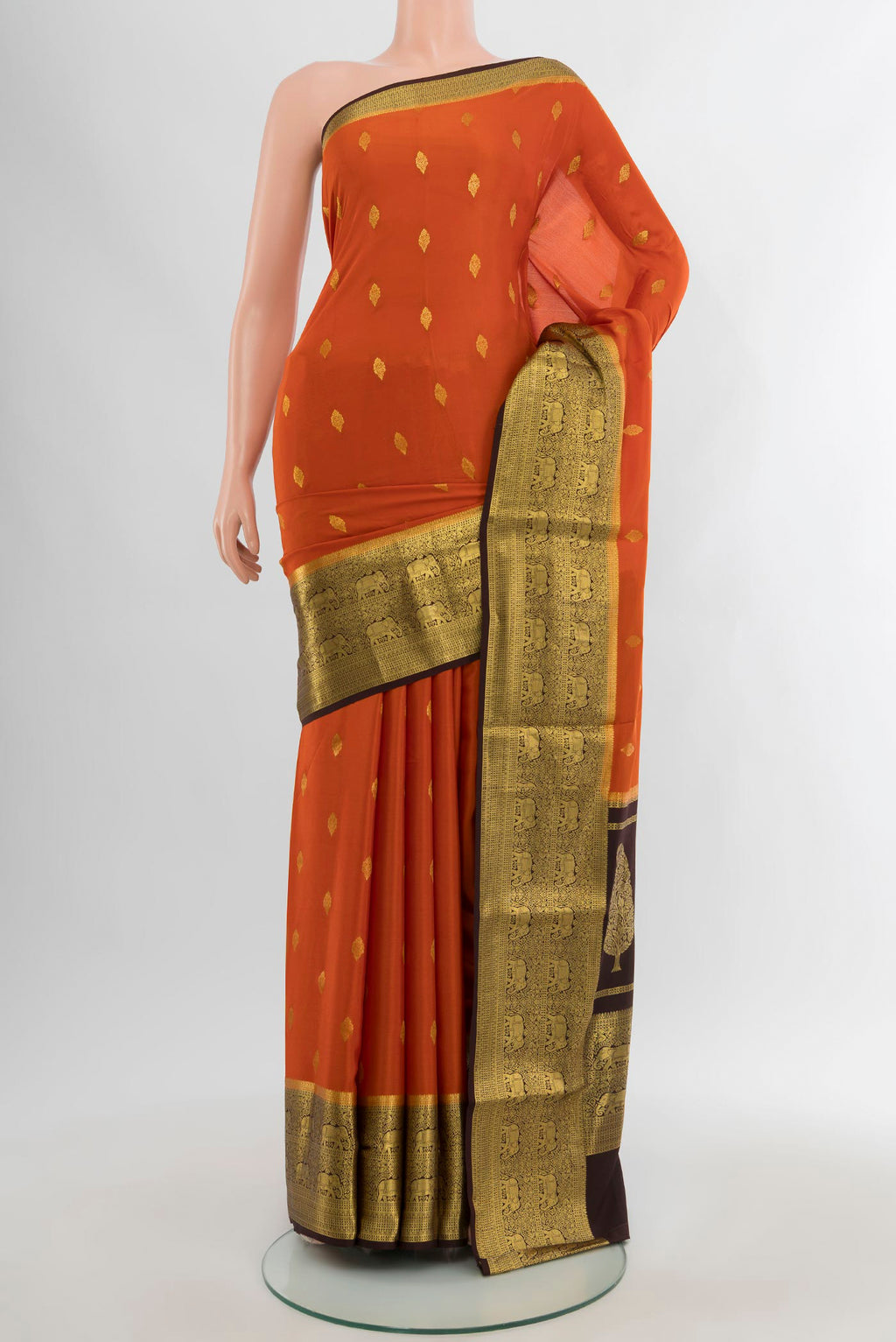 Brick Orange Mysore Crepe Saree with Zari Butta on the body and Zari Border.  displayed on a mannequin