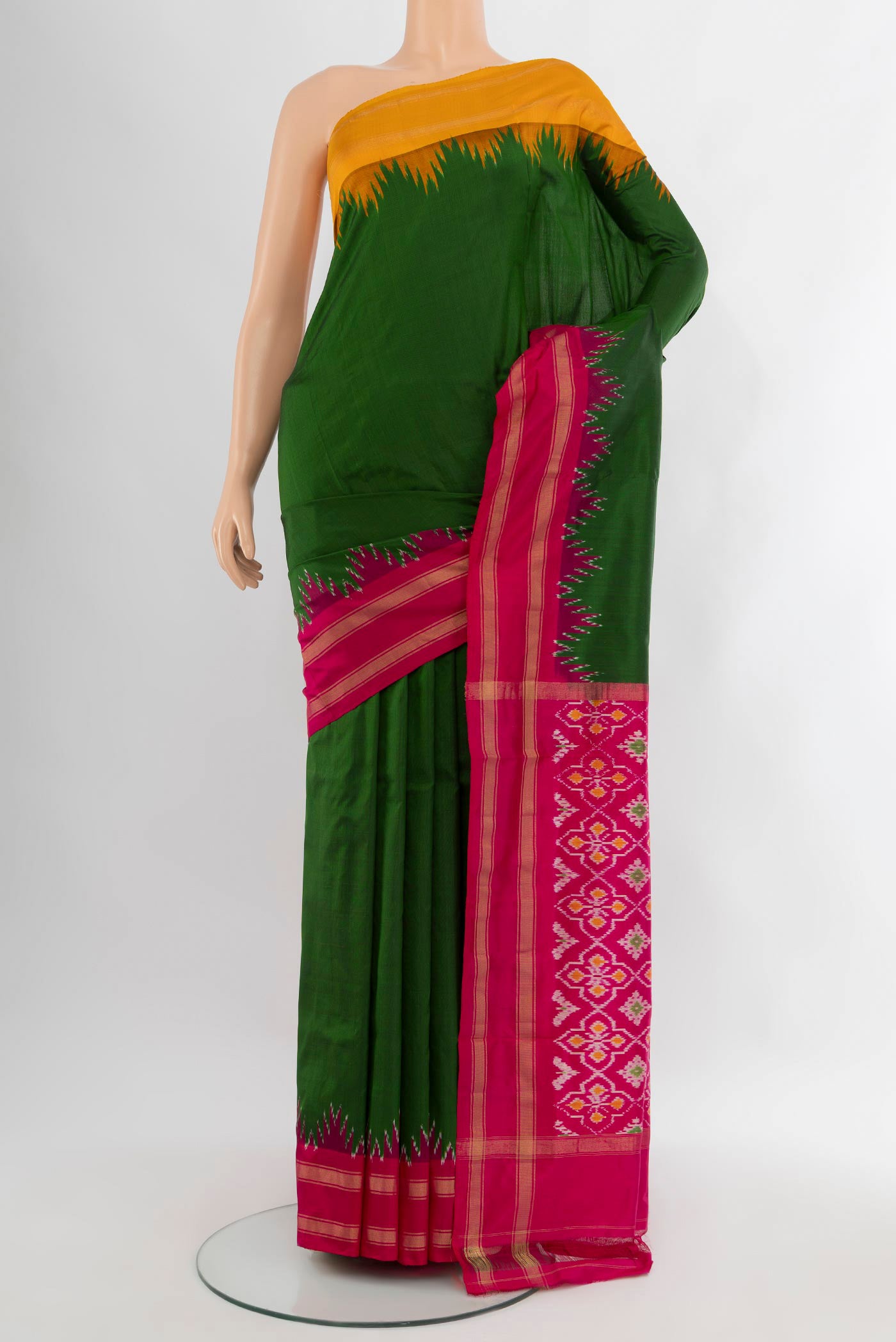 Bottle Green Pochampally Silk Saree with Plain Body and Ganga Jamuna Border.  displayed on a mannequin
