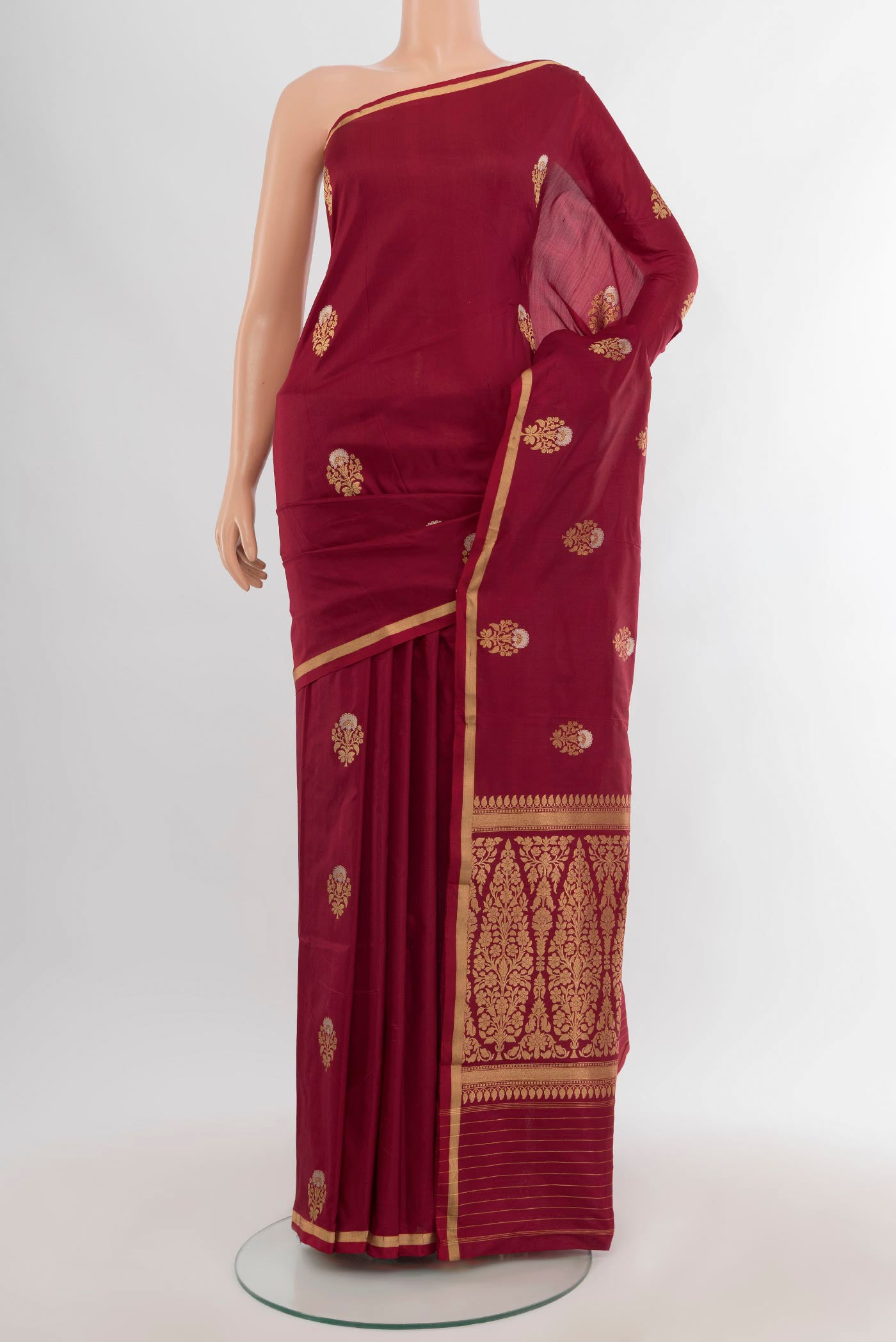Maroon Banarasi Katan Silk Saree with Zari Butta on the body and Zari Border.  displayed on a mannequin