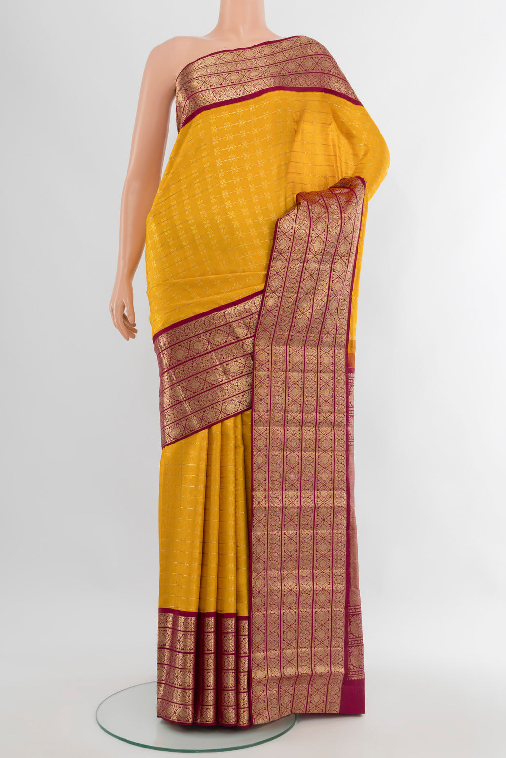 Yellow Kanchipuram Silk Saree with Zari Butta on the body and Zari Border.  displayed on a mannequin