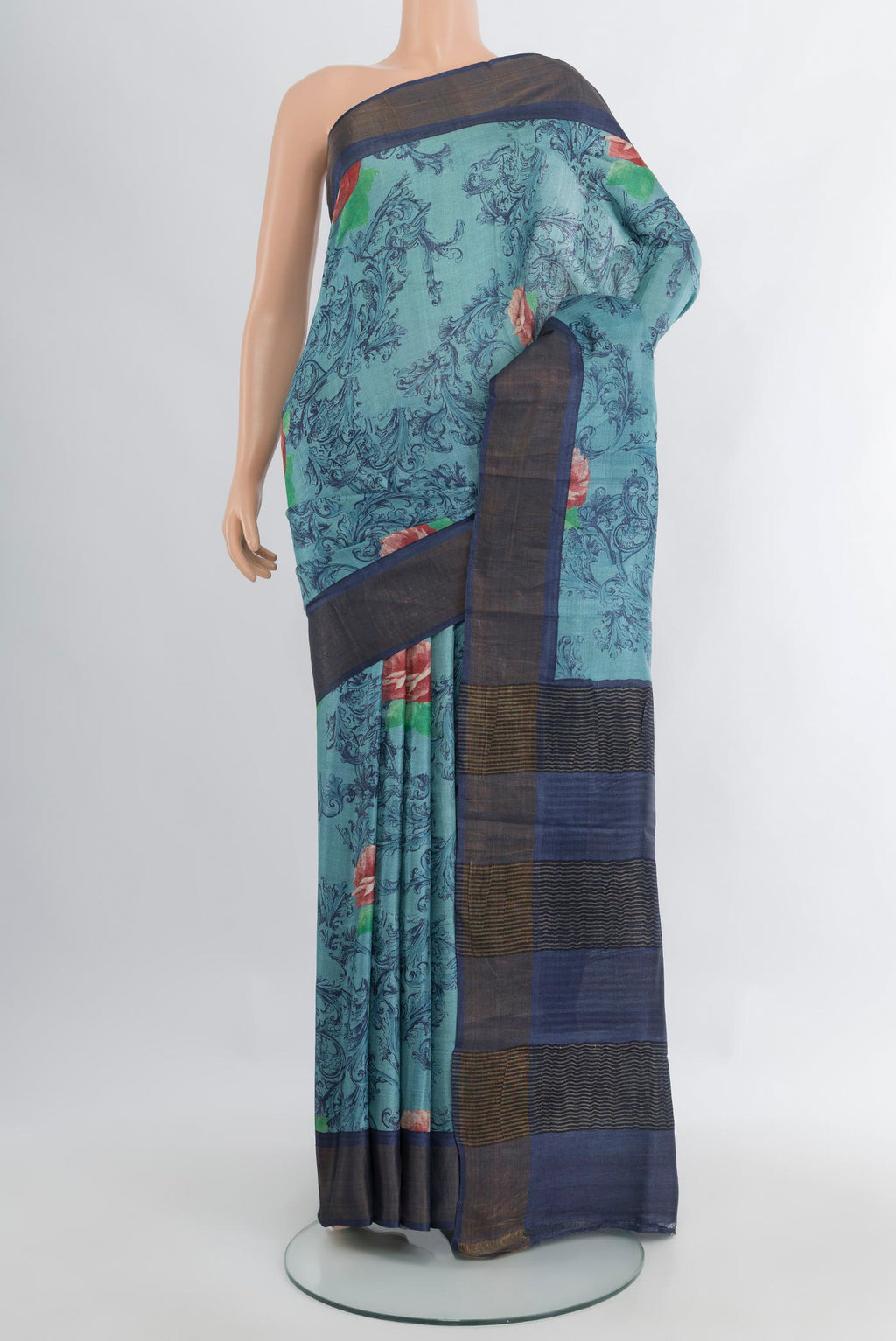 Light Blue Tussar Silk Saree with Floral Print on the body and Zari Border.  displayed on a mannequin