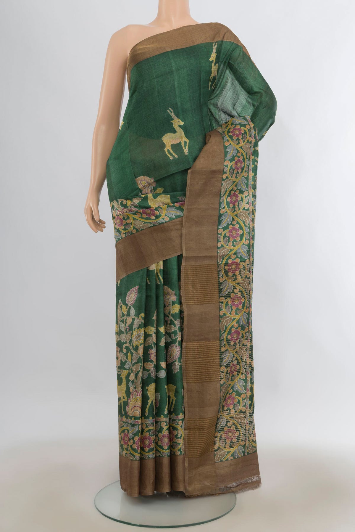 Green Tussar Saree with Printed design on the body and Zari Border.  displayed on a mannequin