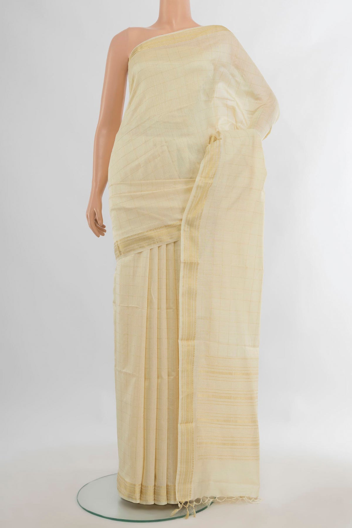 Cream Tussar Saree with Checked design on the body and Zari Border.  displayed on a mannequin