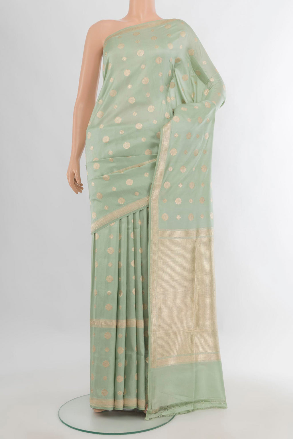 Pure Silk Pista Green Banarasi Saree with Zari Butta on the body and Zari Border.  displayed on a mannequin