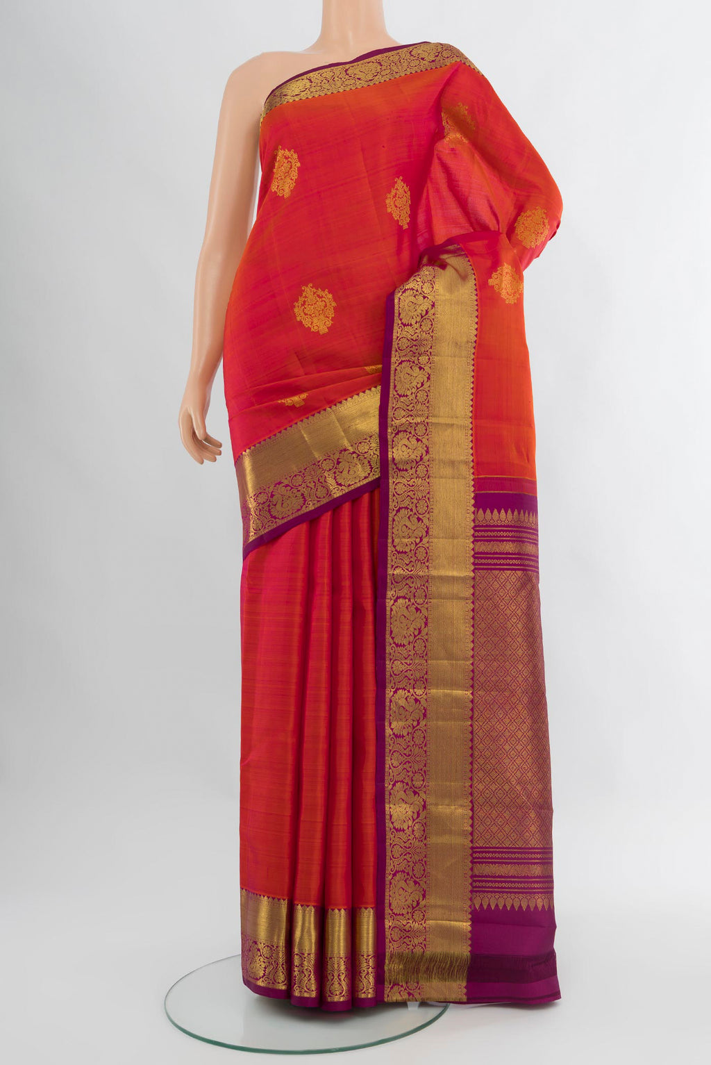 Orange Kanchipuram Silk Saree with Zari Butta on the body and Zari Border.  displayed on a mannequin
