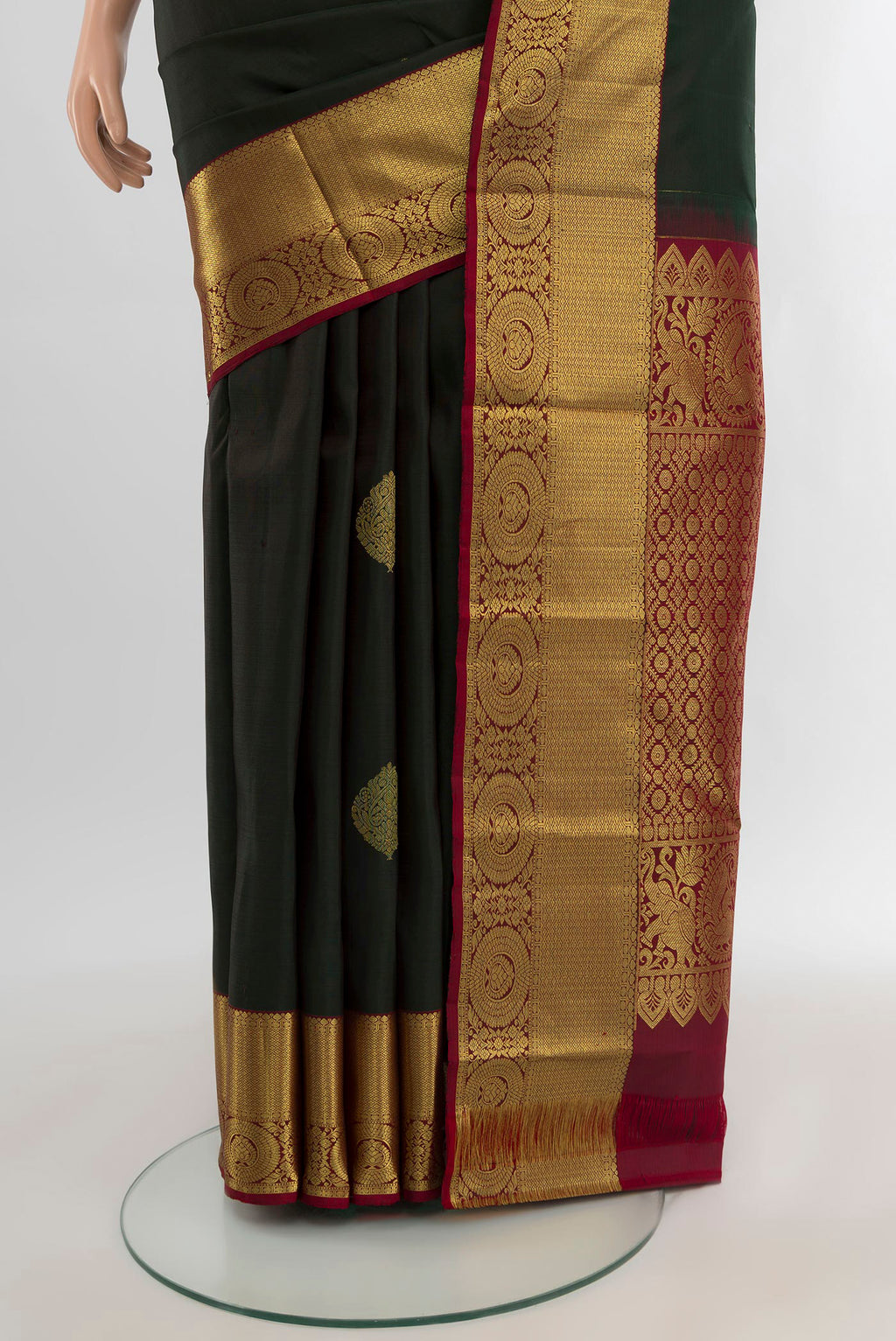 Pleats and pallu of Bottle Green Kanchipuram Silk Saree with Zari Butta on the body and Zari Border. 