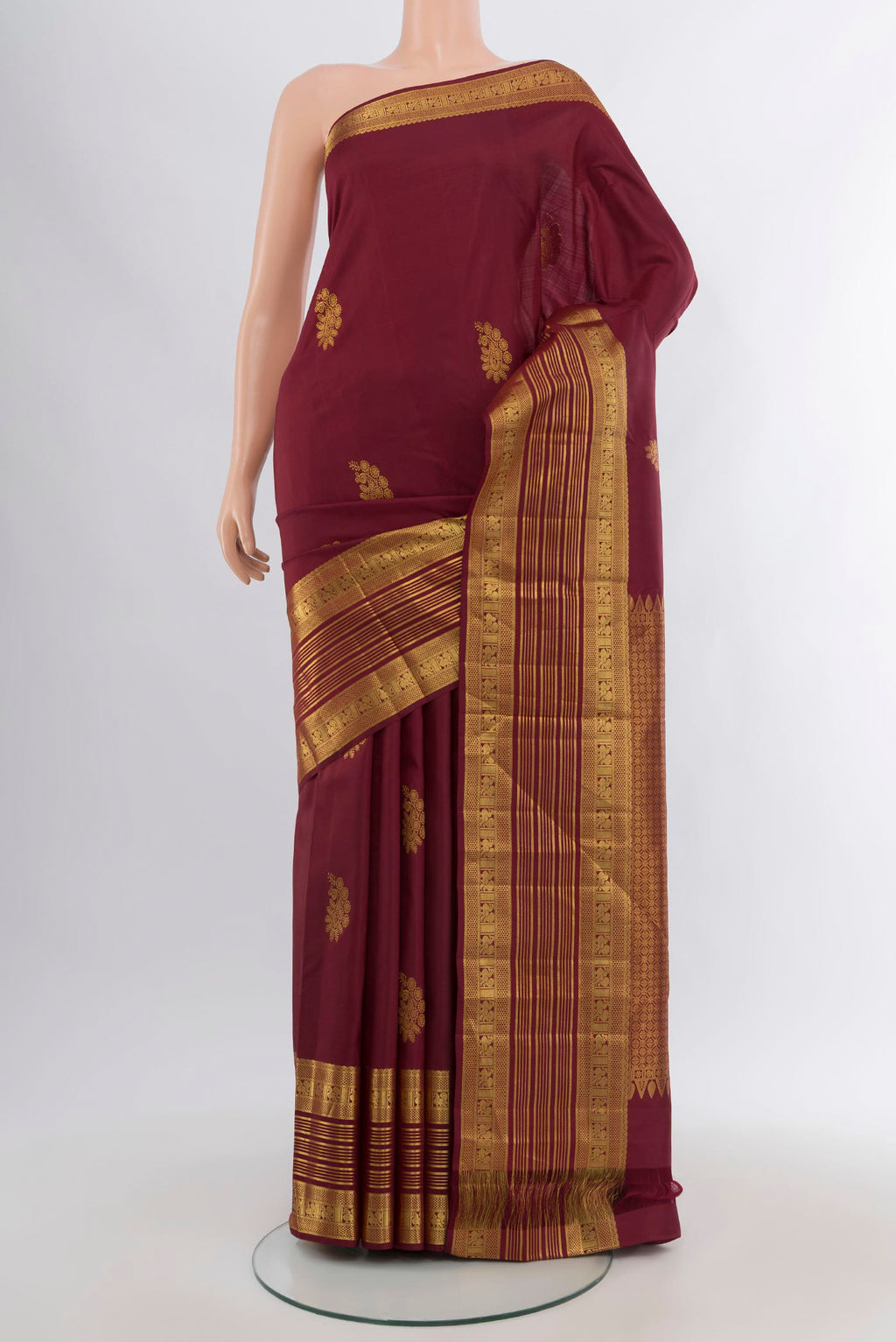 Maroon Kanchipuram Silk Saree with Zari Butta on the body and Zari Border.  displayed on a mannequin