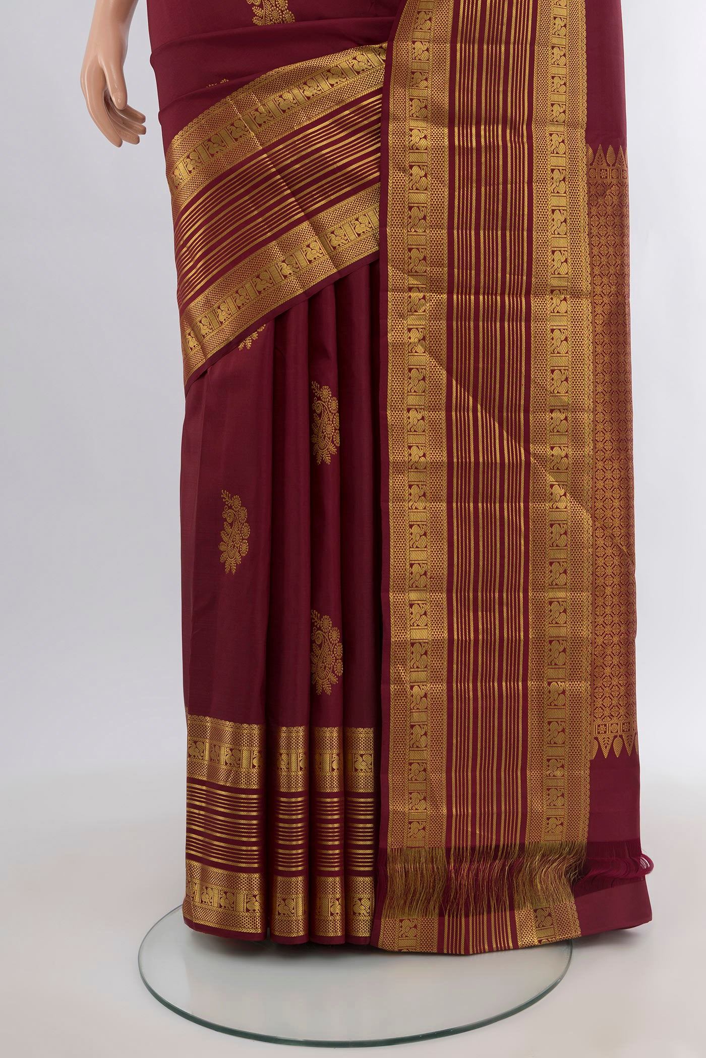 Pleats and pallu of Maroon Kanchipuram Silk Saree with Zari Butta on the body and Zari Border. 
