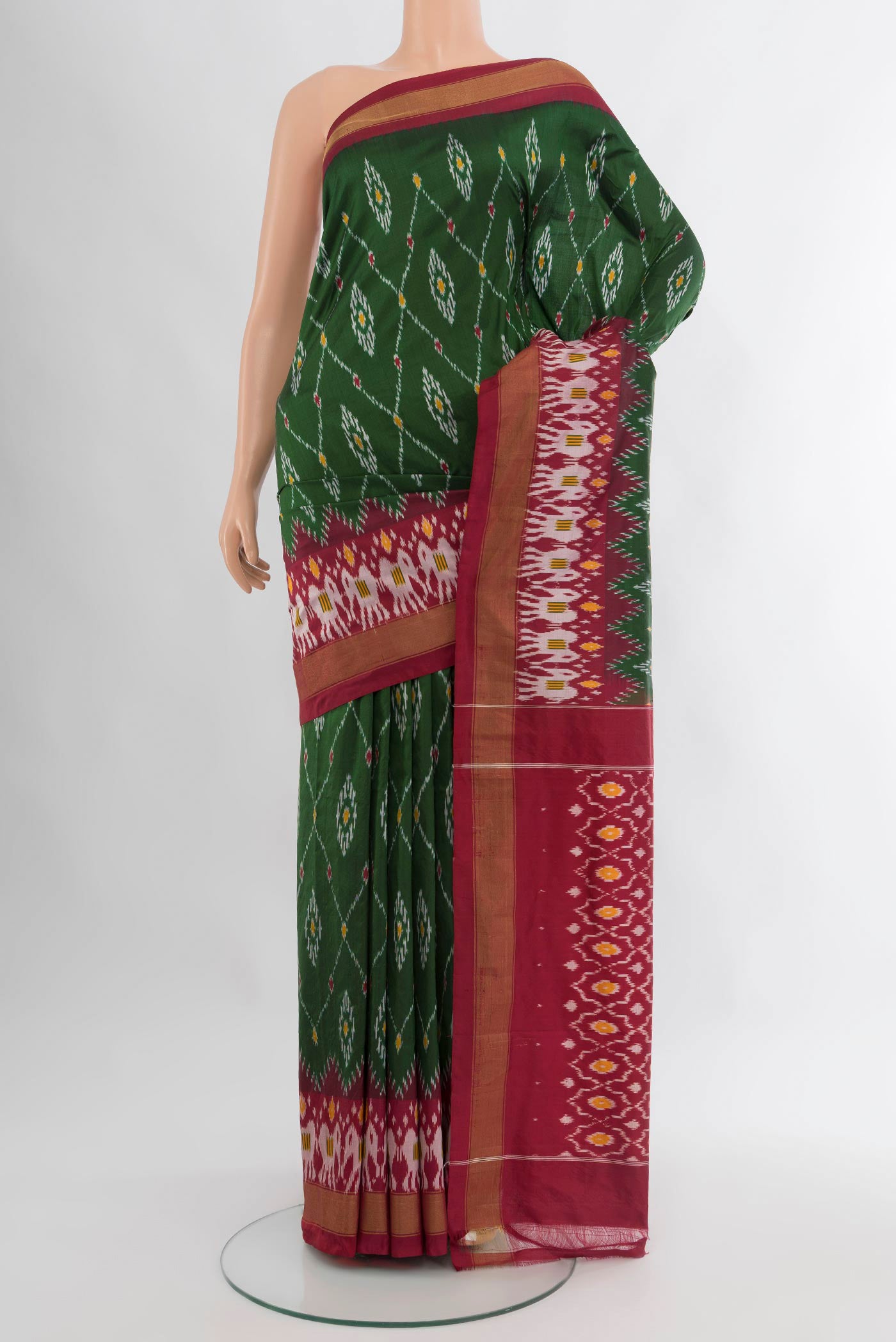 Bottle Green Pochampally Silk Saree with Ikat design on the body and Zari Border.  displayed on a mannequin