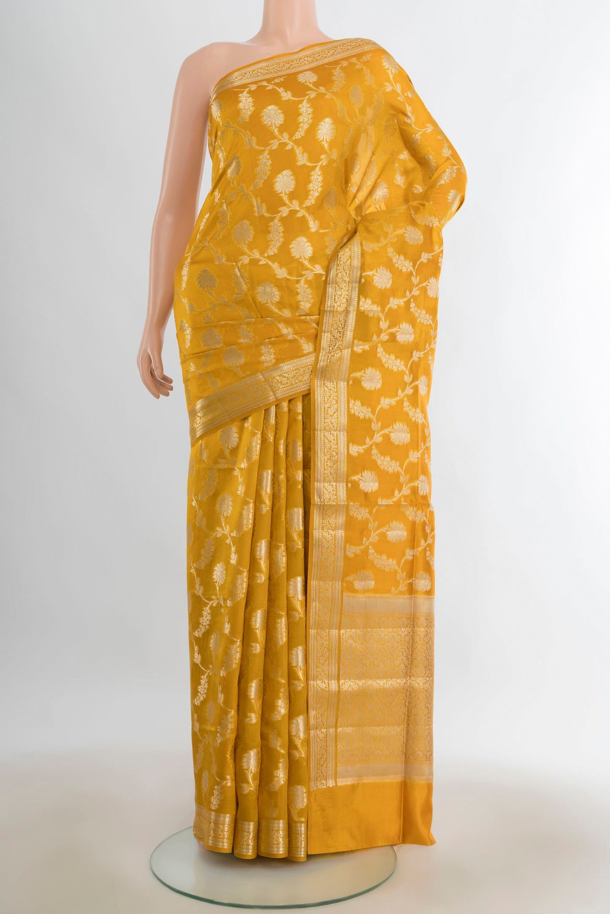 Pure Silk Mustard Banarasi Raw Saree with Zari Butta on the body and Silk Border.  displayed on a mannequin