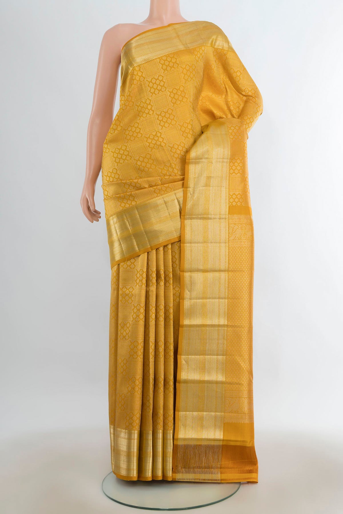 Pure Silk Mustard Kanchipuram Saree with Zari Butta on the body and Silk Border.  displayed on a mannequin