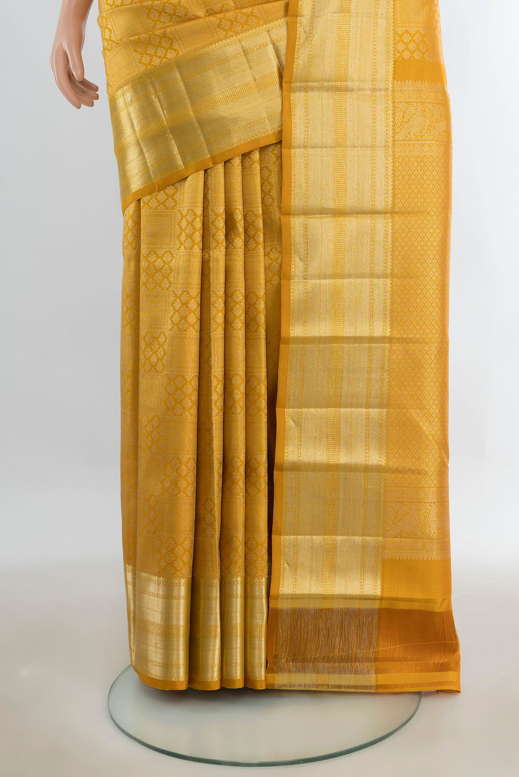Pleats and pallu of Pure Silk Mustard Kanchipuram Saree with Zari Butta on the body and Silk Border. 