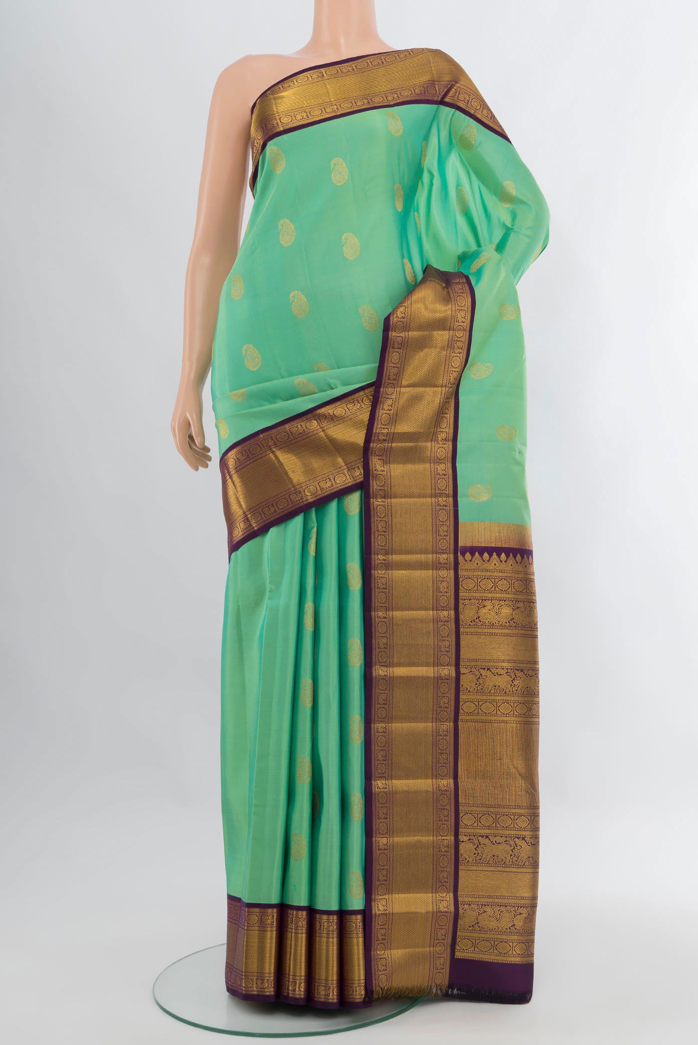 Sea Green Kanjivaram Silk Saree with Zari Butta on the body and Zari Border.  displayed on a mannequin