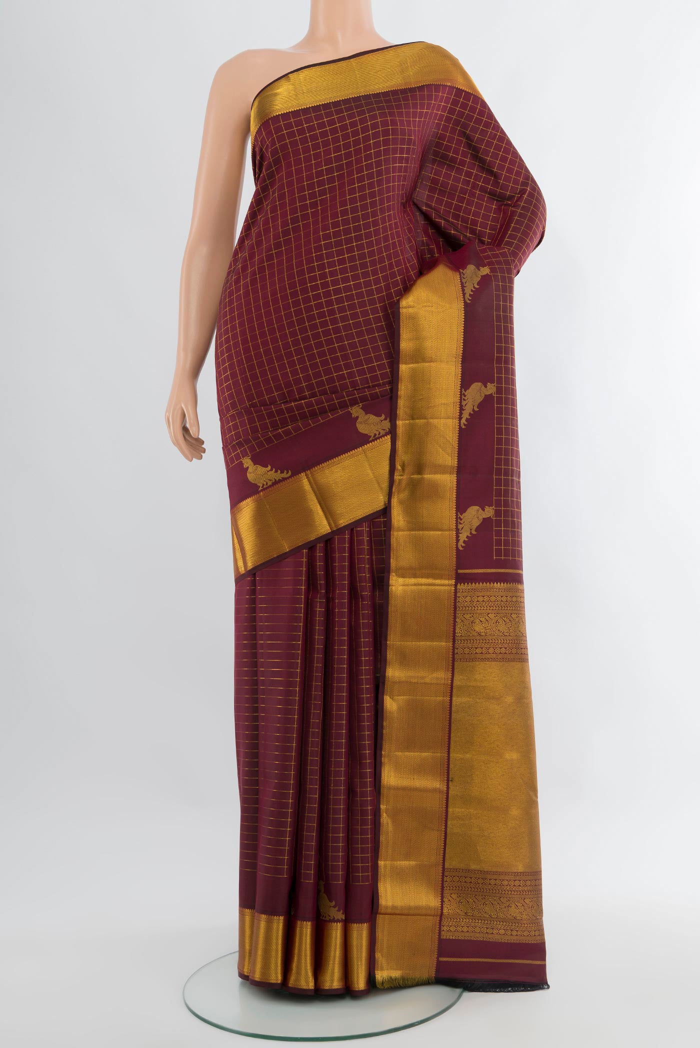 Maroon Kanchipuram Silk Saree with Checked design on the body and Zari Border.  displayed on a mannequin