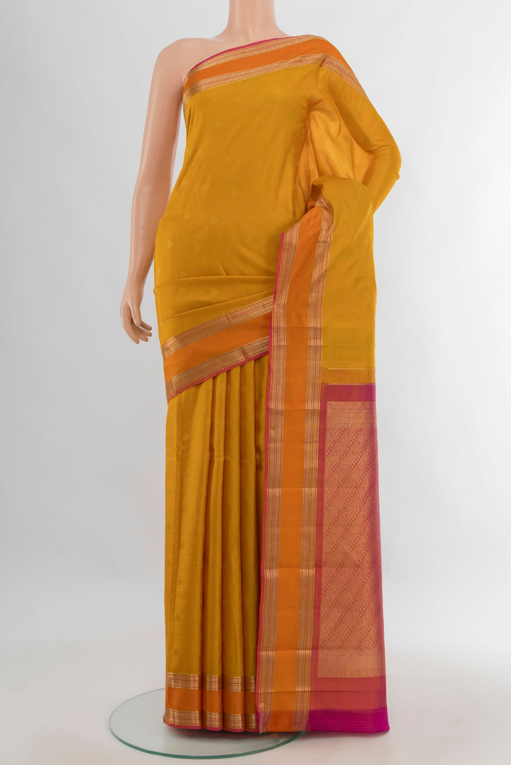 Pure Silk Mustard Kanchipuram Saree with Zari Butta on the body and Zari Border.  displayed on a mannequin