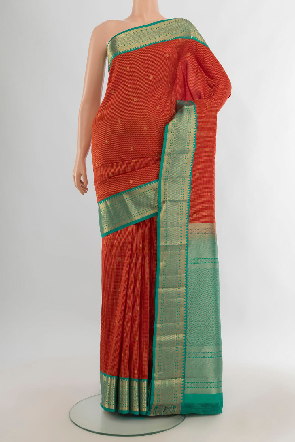 Pure Silk Orange Kanjivaram Saree with Zari Butta on the body and Zari Border.  displayed on a mannequin