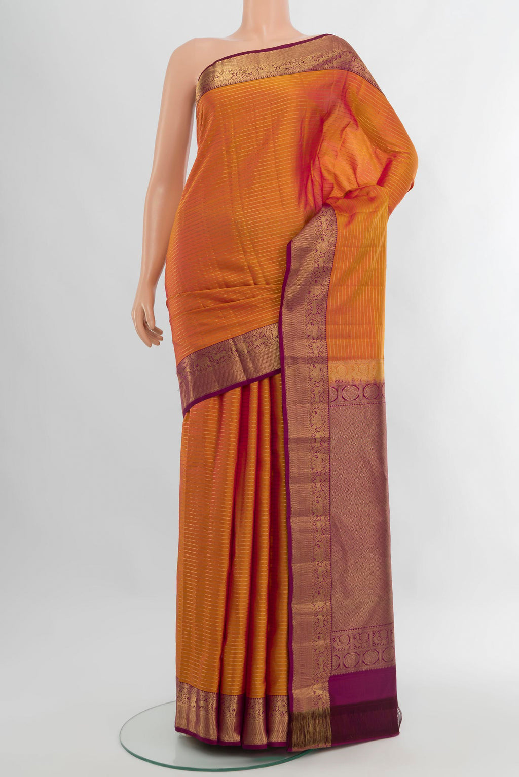 Mustard Kanjivaram Silk Saree with Stripes on the body and Zari Border.  displayed on a mannequin