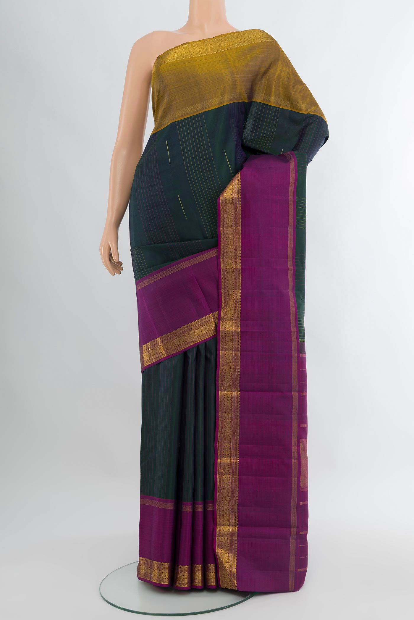 Bottle Green Kanjivaram Silk Saree with Plain Body and Plain Border.  displayed on a mannequin