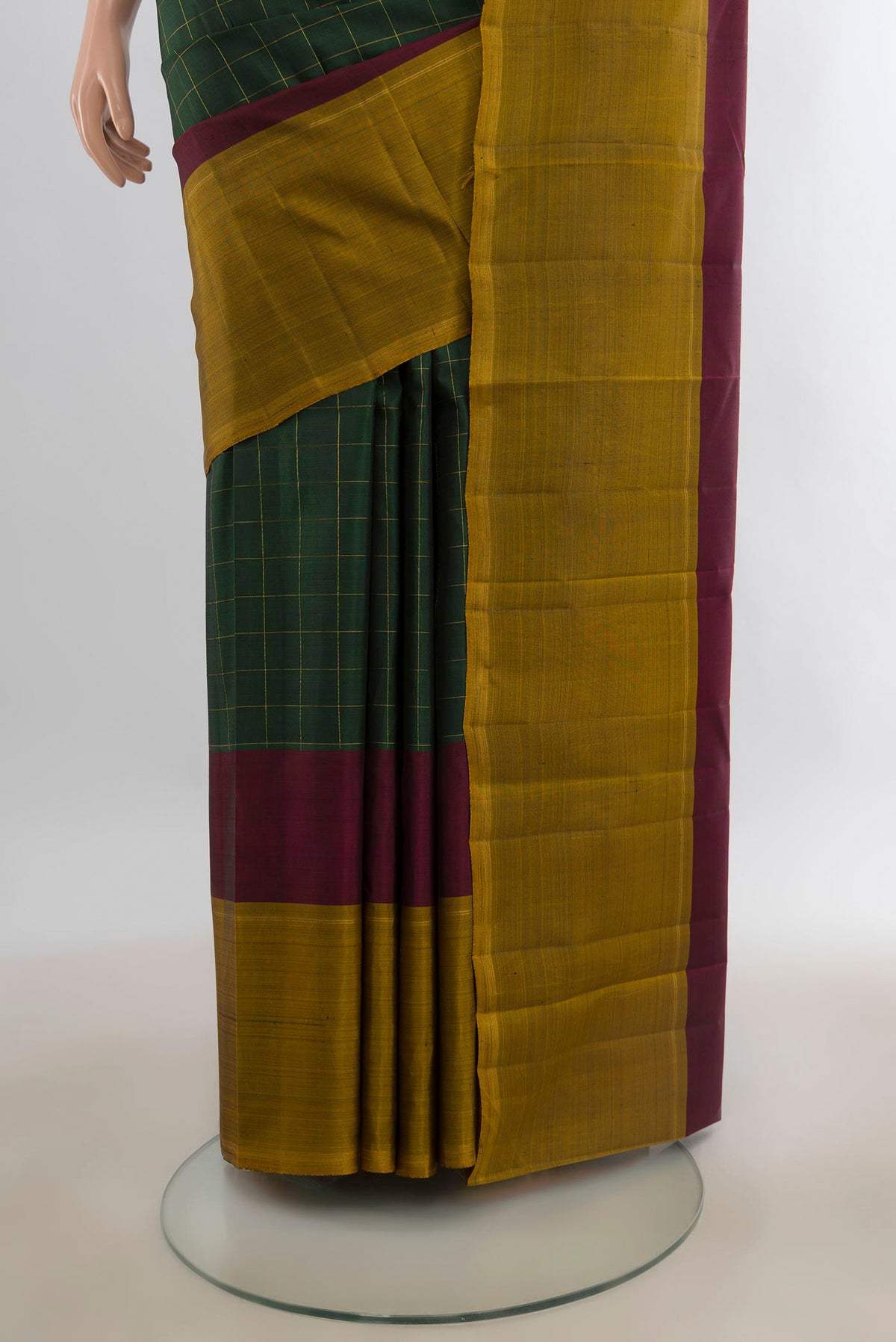 Pleats and pallu of Pure Silk Bottle Green Kanchipuram Saree with Checked design on the body and Plain Border. 