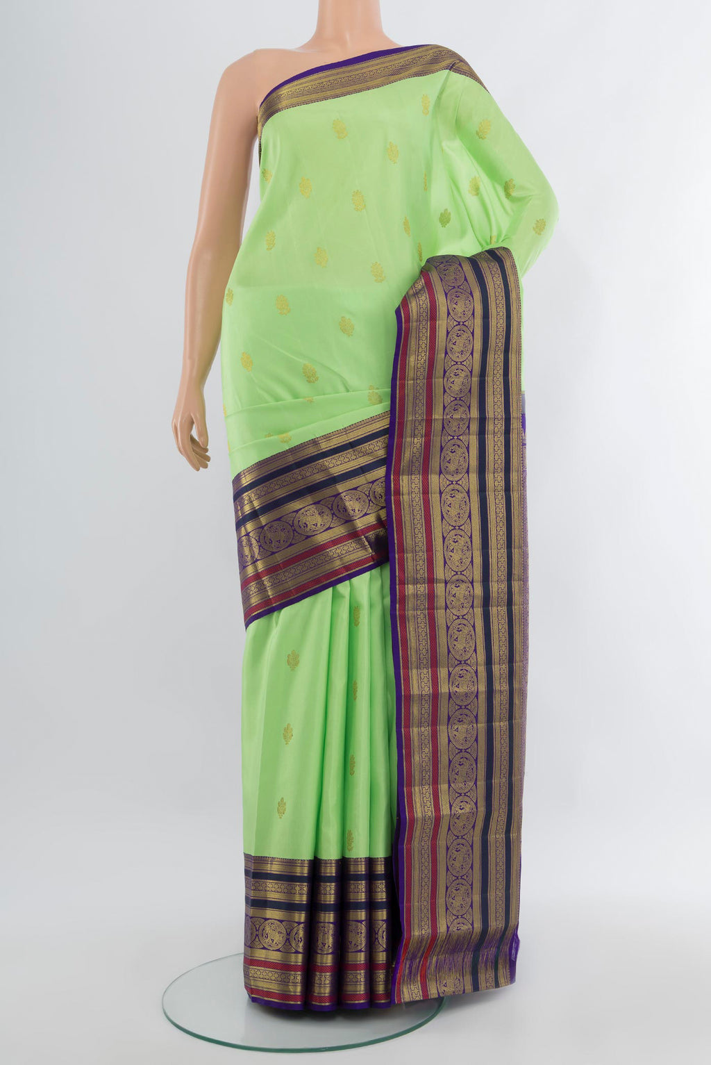 Pista Green Kanjivaram Silk Saree with Zari Butta on the body and Zari Border.  displayed on a mannequin