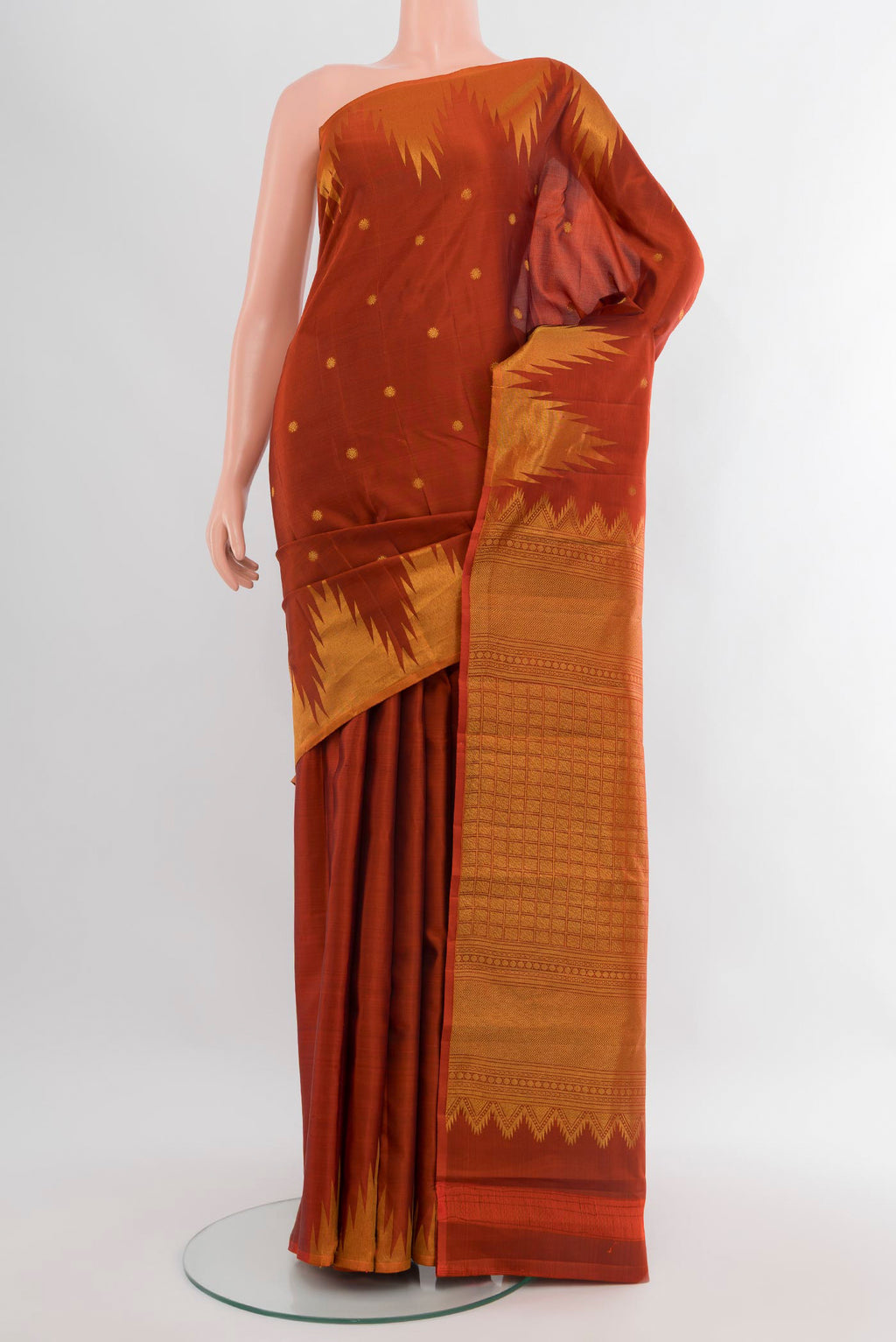 Rust Kanchipuram Silk Saree with Zari Butta on the body and Temple Border.  displayed on a mannequin