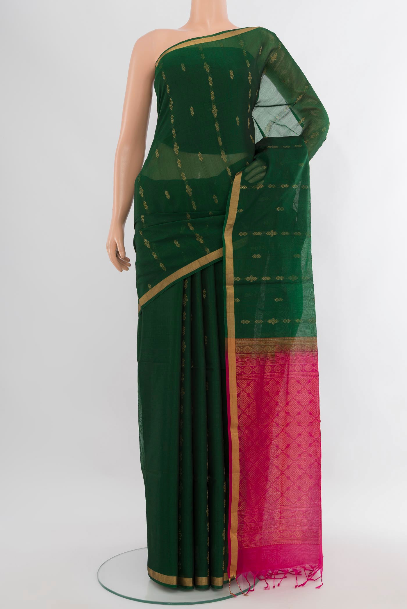 Bottle Green Silk Cotton Saree with Zari Butta on the body and Zari Border.  displayed on a mannequin
