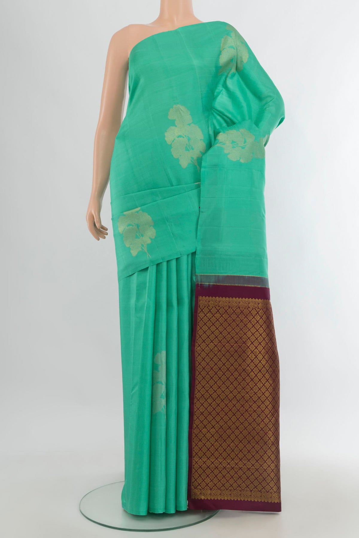 Pure Silk Green Kanjivaram Saree with Zari Butta on the body and Without Border.  displayed on a mannequin