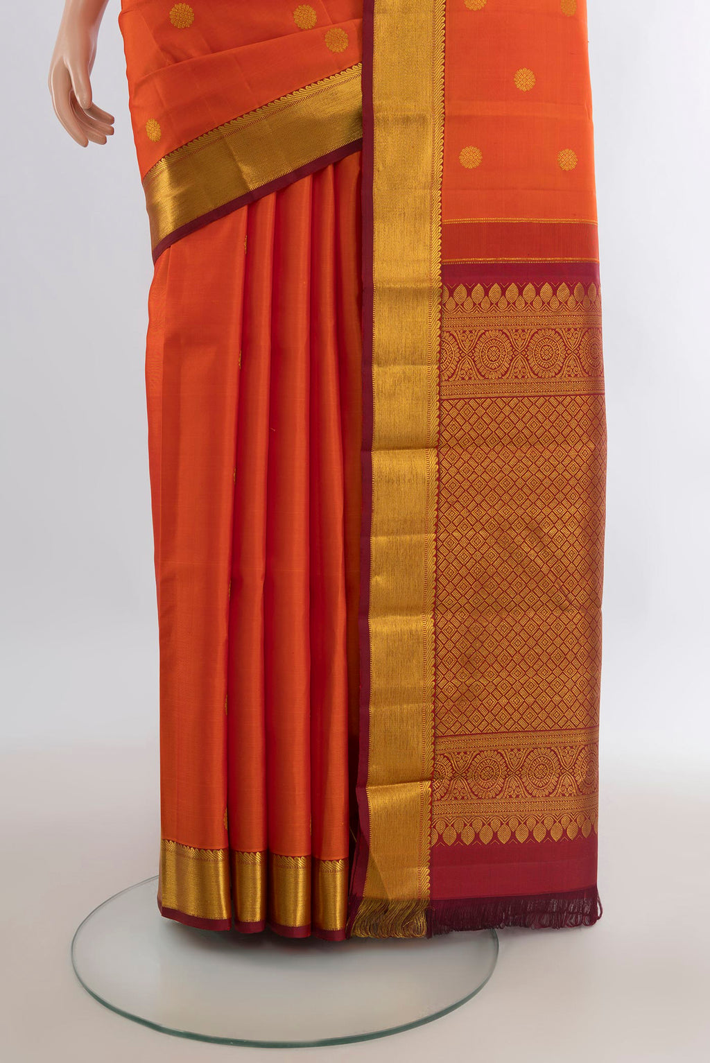 Pleats and pallu of Pure Silk Orange Kanjivaram Saree with Zari Butta on the body and Zari Border. 