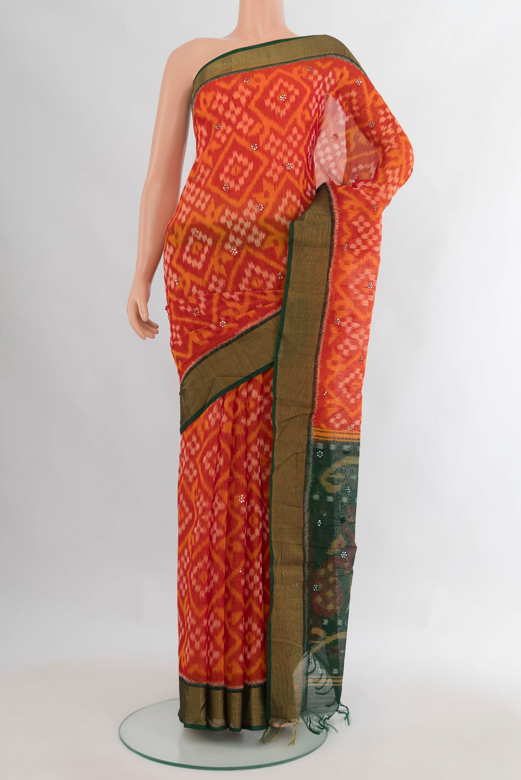 Orange Silk Cotton Saree with Ikat Print on the body and Zari Border.  displayed on a mannequin