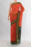 Orange Silk Cotton Saree with Ikat Print on the body and Zari Border.  displayed on a mannequin