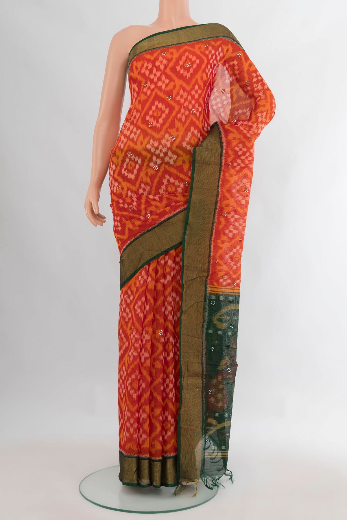 Orange Silk Cotton Saree with Ikat Print on the body and Zari Border.  displayed on a mannequin