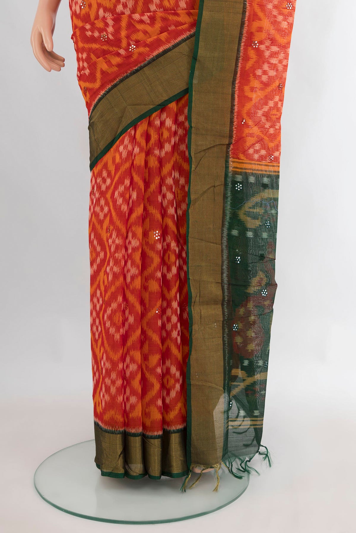 Pleats and pallu of Orange Silk Cotton Saree with Ikat Print on the body and Zari Border. 