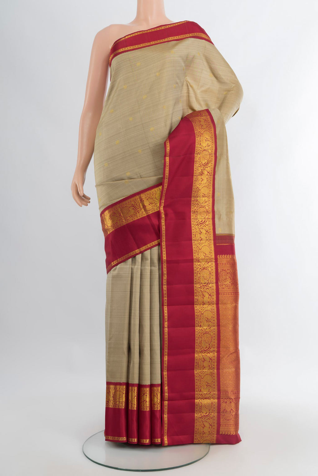 Beige Kanchipuram Silk Saree with Zari Butta on the body and Zari Border.  displayed on a mannequin
