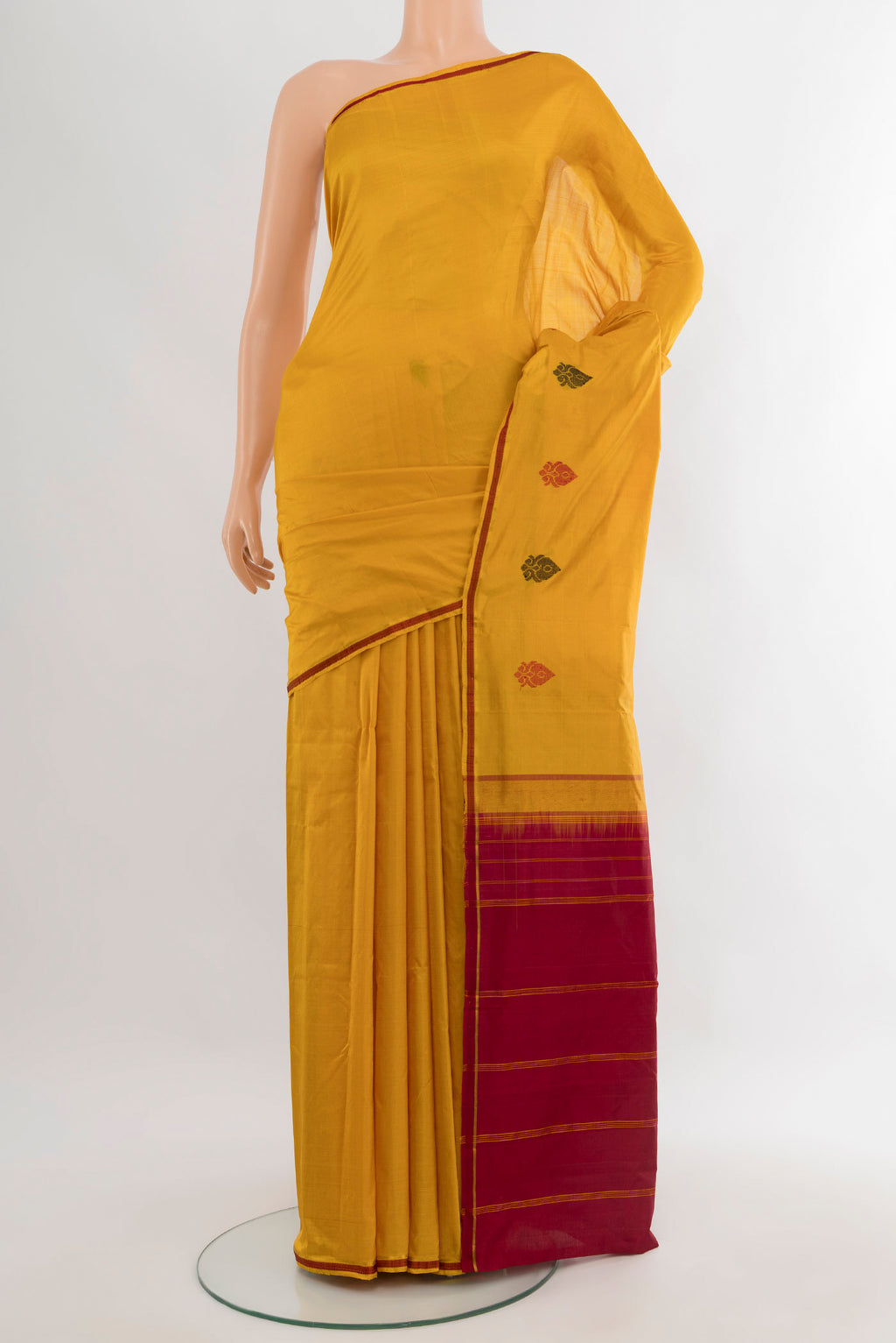 Mustard Kanchipuram Silk Saree with Plain Body and Thread Border.  displayed on a mannequin