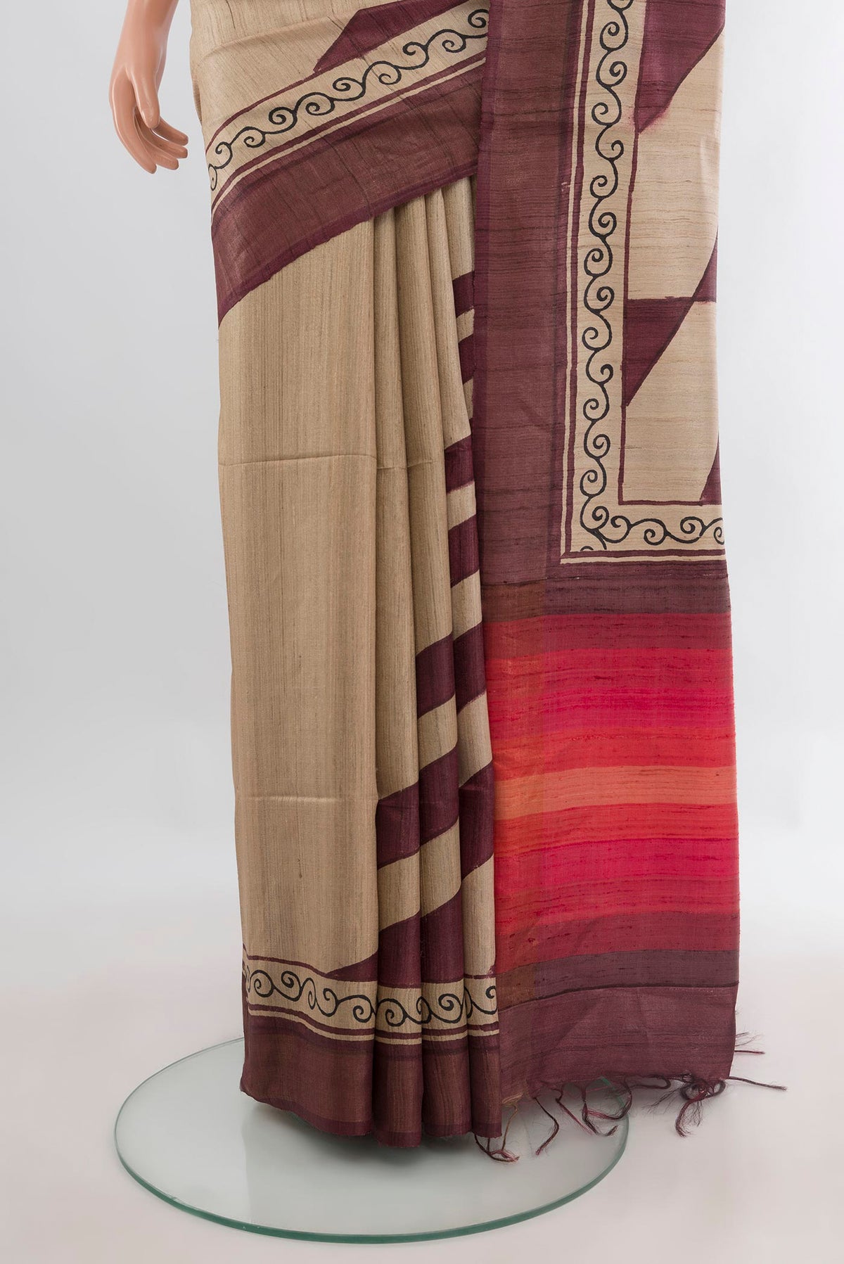Pleats and pallu of Beige Tussar Saree with Printed design on the body and Zari Border. 