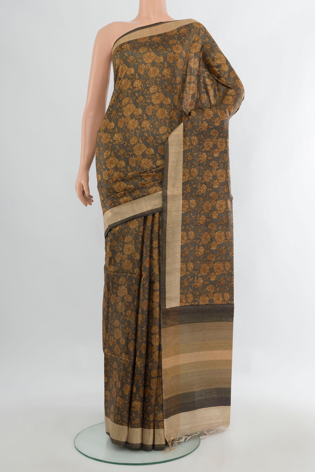 Brown Tussar Saree with Floral Print on the body and Zari Border.  displayed on a mannequin