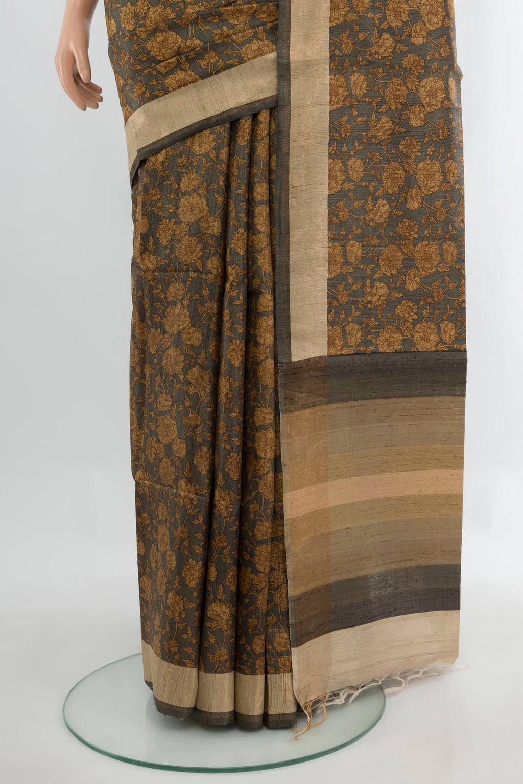 Pleats and pallu of Brown Tussar Saree with Floral Print on the body and Zari Border. 