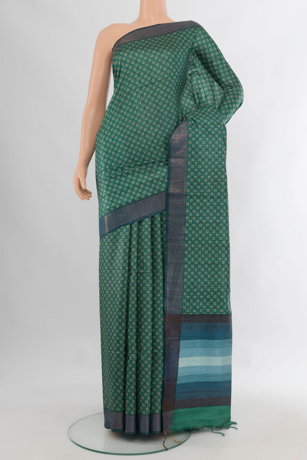 Green Tussar Saree with Printed design on the body and Zari Border.  displayed on a mannequin