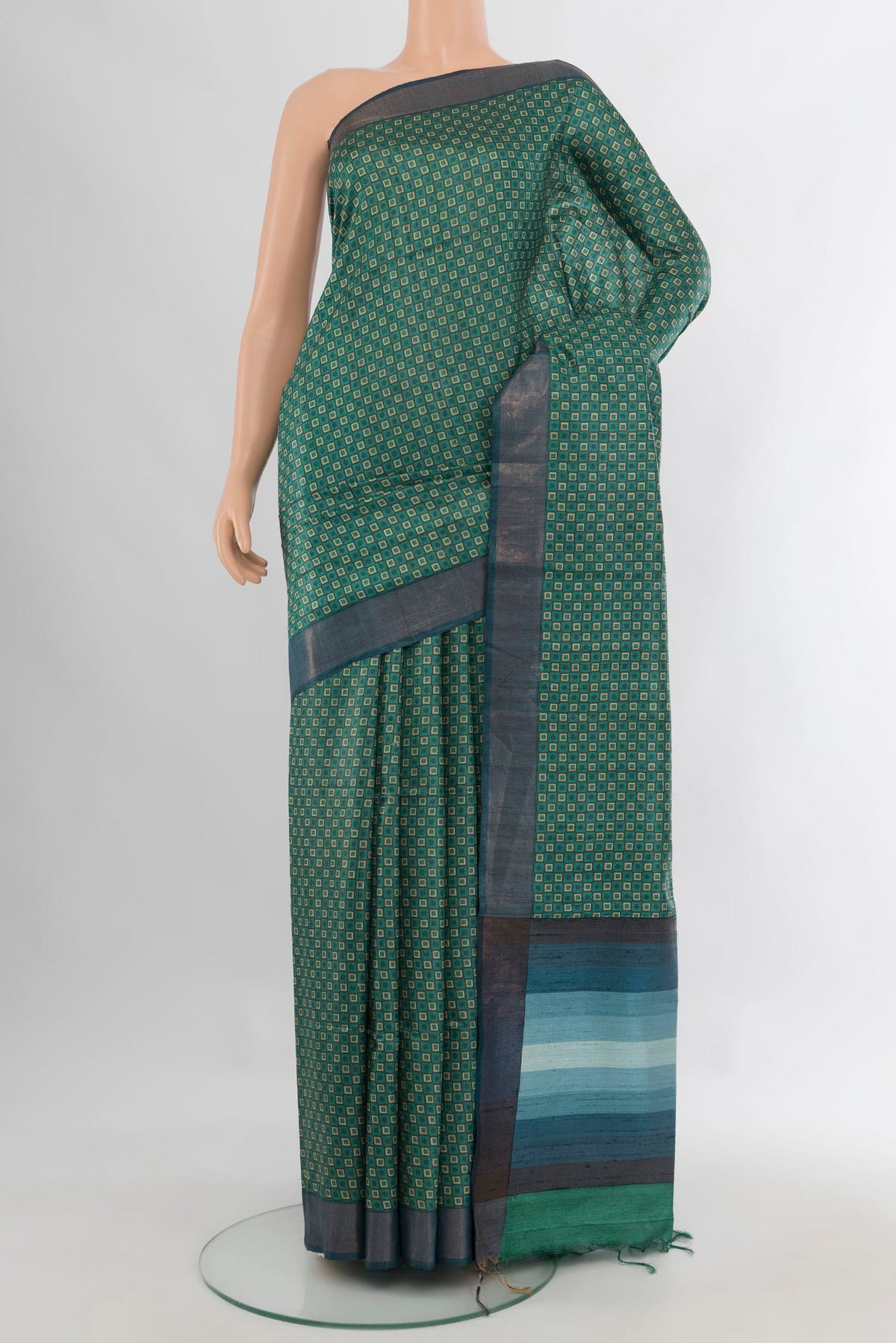 Green Tussar Saree with Printed design on the body and Zari Border.  displayed on a mannequin