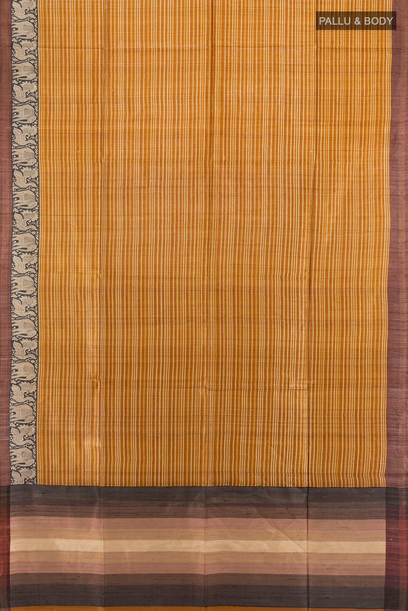 Flat view of Mustard Tussar Saree with Printed design on the body and Zari Border. 