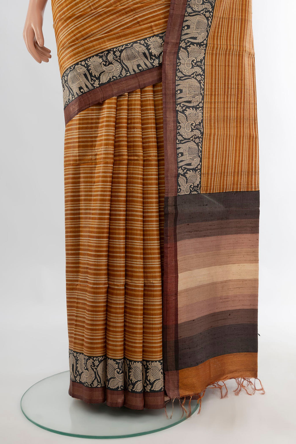 Pleats and pallu of Mustard Tussar Saree with Printed design on the body and Zari Border. 