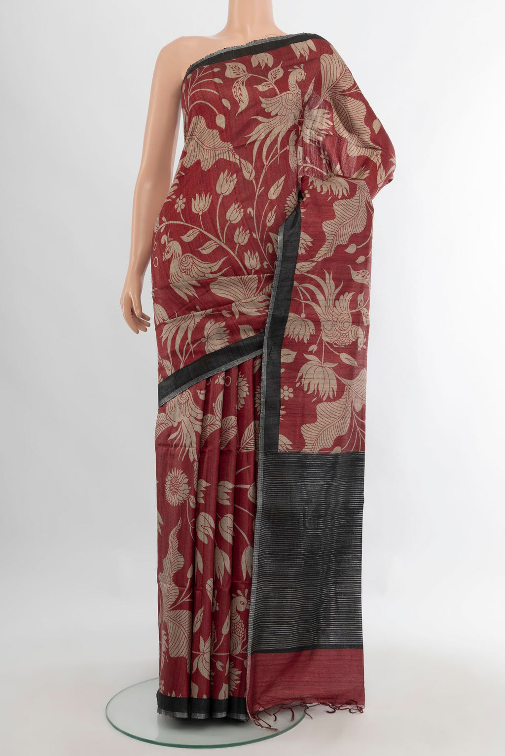 Maroon Tussar Saree with Floral Print on the body and Zari Border.  displayed on a mannequin