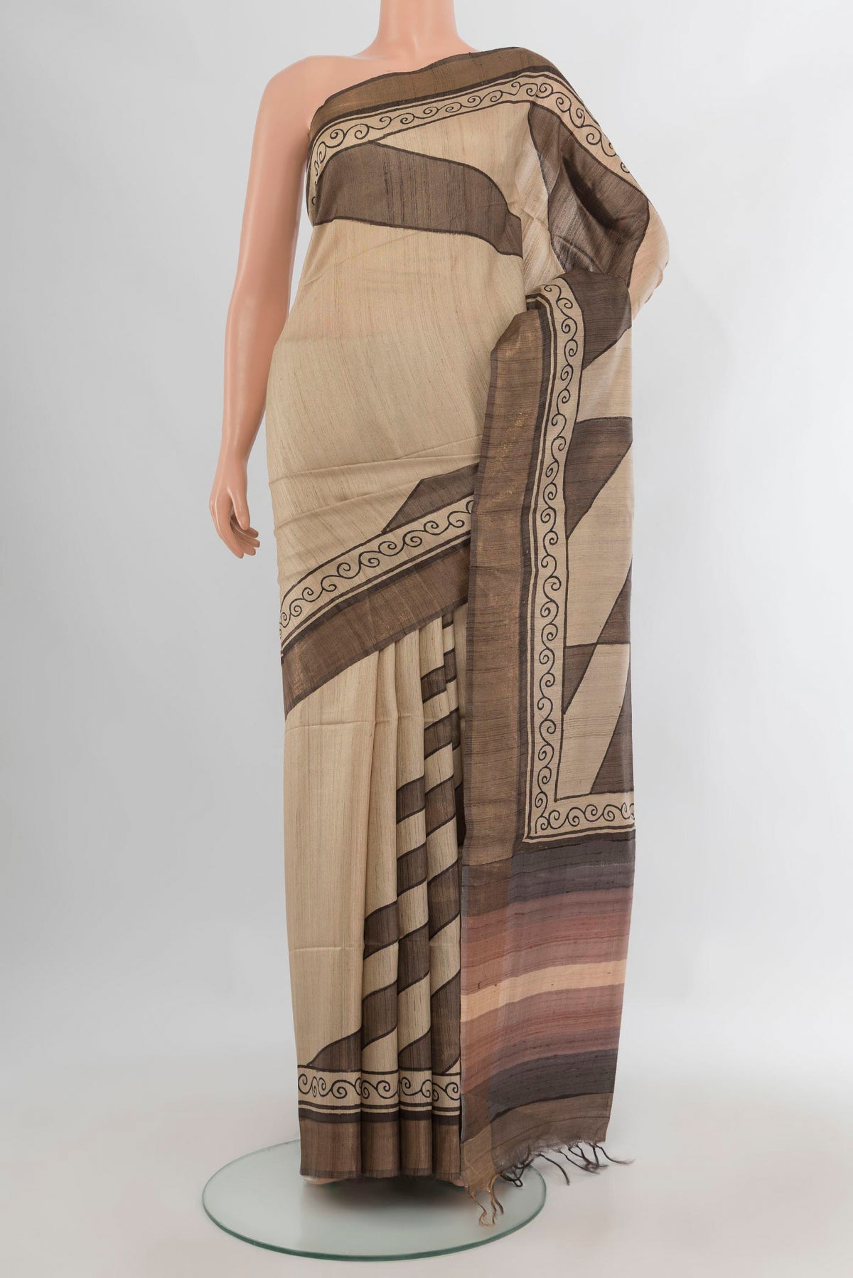 Beige Tussar Saree with Printed design on the body and Zari Border.  displayed on a mannequin