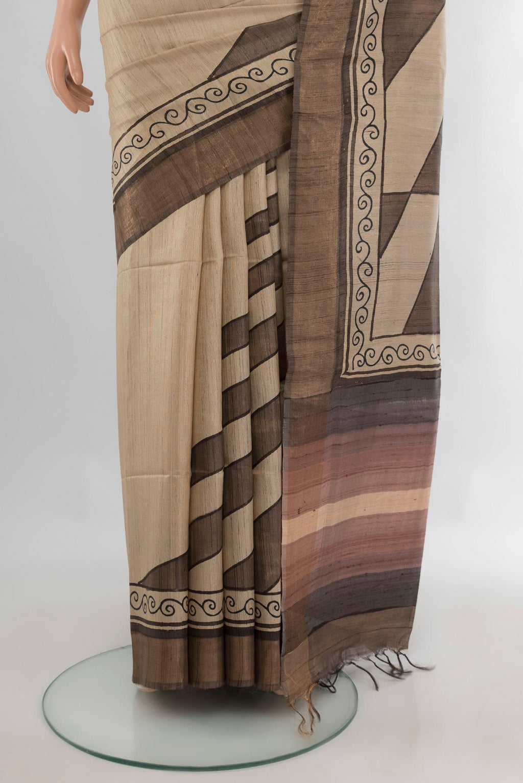 Pleats and pallu of Beige Tussar Saree with Printed design on the body and Zari Border. 