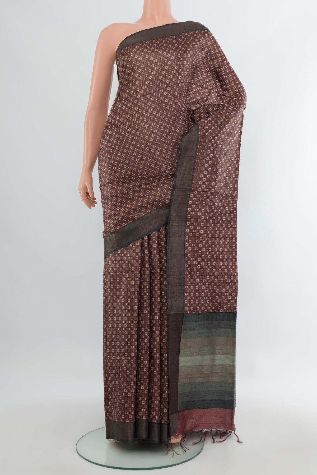 Brown Tussar Saree with Printed design on the body and Zari Border.  displayed on a mannequin