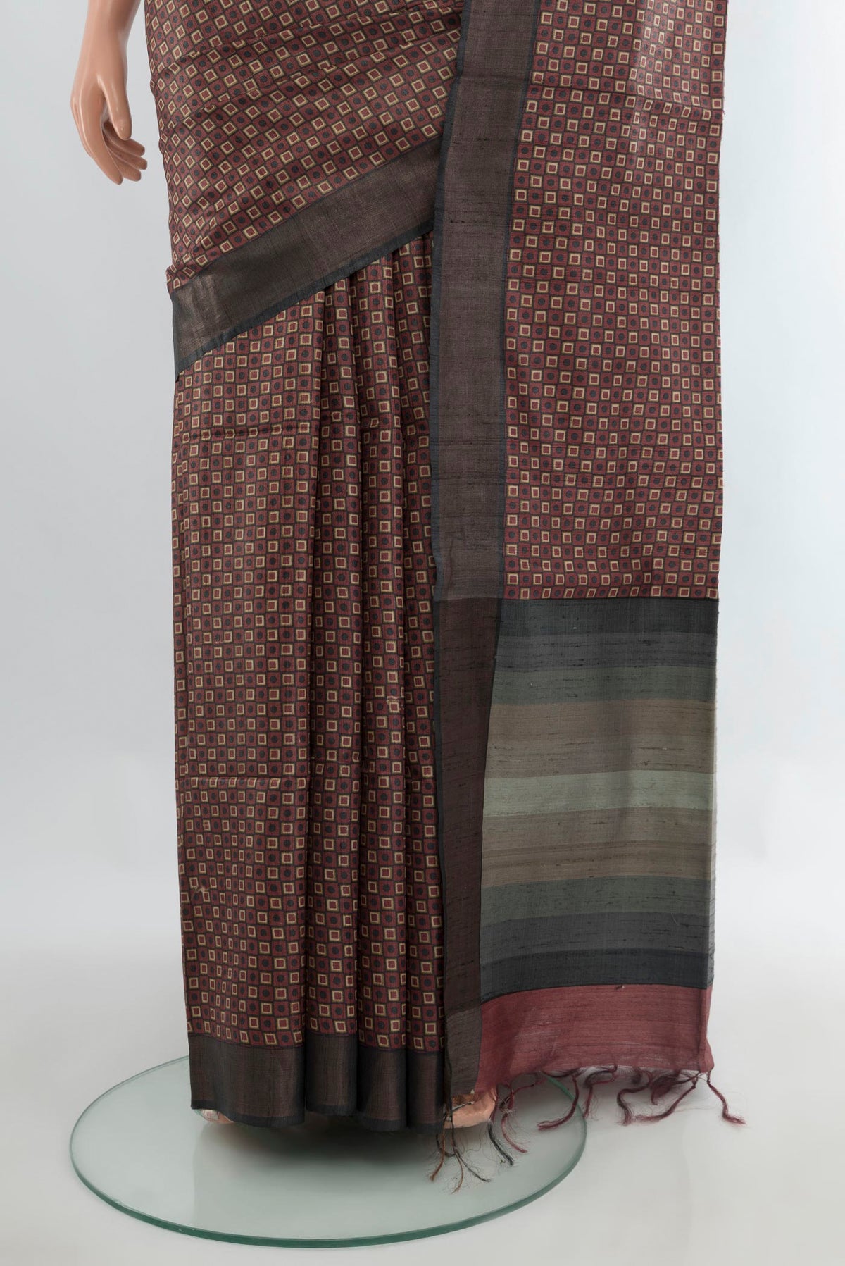 Pleats and pallu of Brown Tussar Saree with Printed design on the body and Zari Border. 